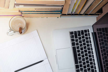 flat lay workplace with books, notebook, pencil, coffee and computer. e-learningの写真素材