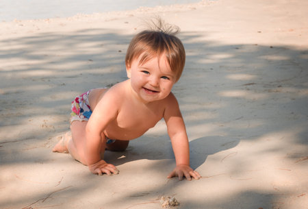 smiling baby on the beach. child crawling on the sand