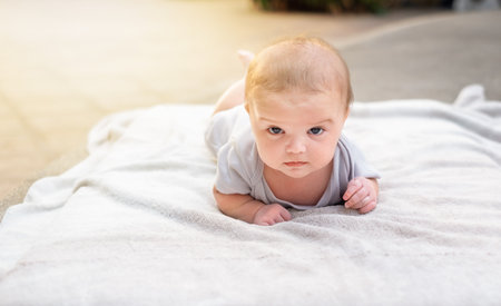 the baby sunbathes in the sun. baby lies on a towel under the sunの写真素材