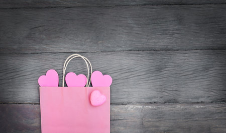 pink paper bag with pink hearts on wooden backgroundの写真素材
