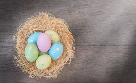 Easter eggs in the nest. Easter nest on wooden background
