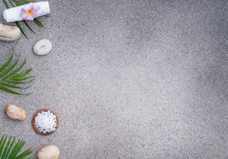 Spa set on a stone background. Sea salt, towel with stones