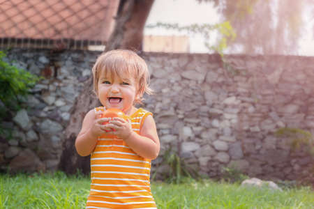 Portrait of a happy baby in the backyard. A child playing on the grassの写真素材