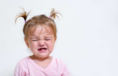 Portrait of an upset child. Girl crying on the background of the wallの写真素材