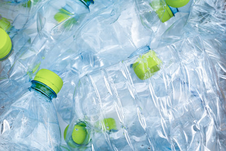 Lots of blue plastic bottles with green caps background