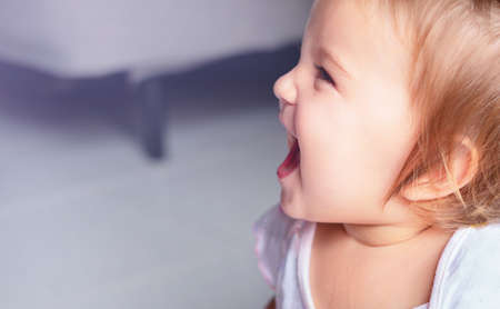 Portrait of a baby in profile. The child laughs