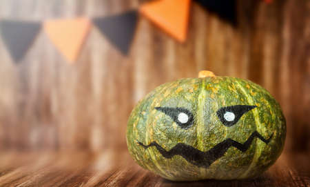 Painted Halloween green pumpkin on a wooden backgroundの写真素材