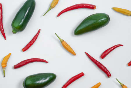 Several types of peppers on the white surfaceの写真素材
