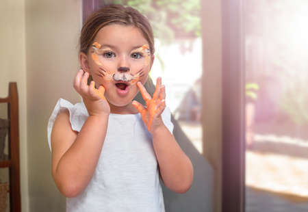 Portrait of a surprised child with a painted face on the holiday
