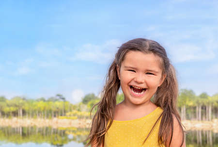 Portrait of a happy child near the lake in summerの写真素材