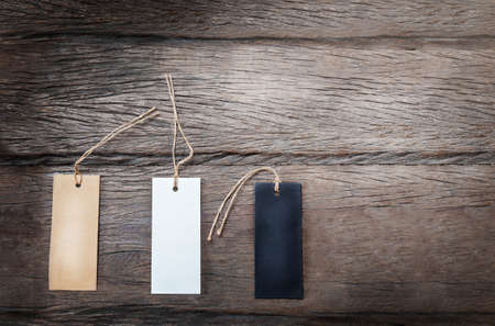 Three different cardboard tags on the dark wooden backgroundの写真素材