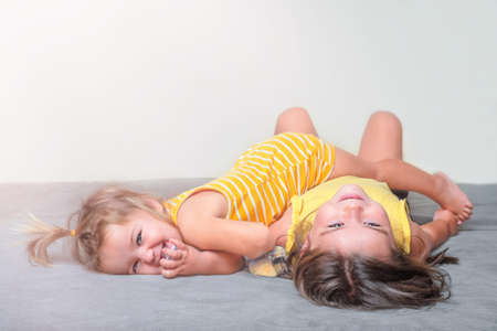 Sisters children play on the sofa togetherの写真素材