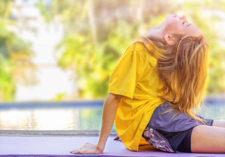 Teenage girl doing exercises during morning workout outdoors