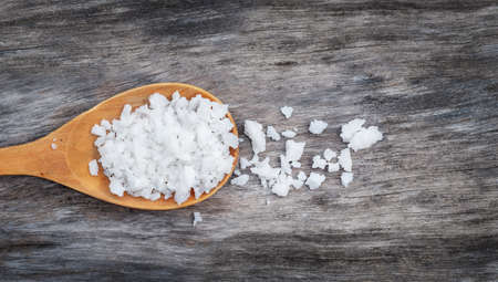 Sea salt in spoon on wooden backgroundの写真素材