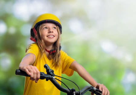 Portrait of a teenager girl in a helmet on a bicycle outdoorの写真素材