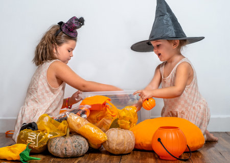 Children take apart a container of Halloween decorationsの写真素材