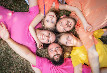 Happy big family lies on the grass together