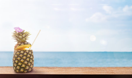 Pineapple on a wooden surface by the seaの写真素材