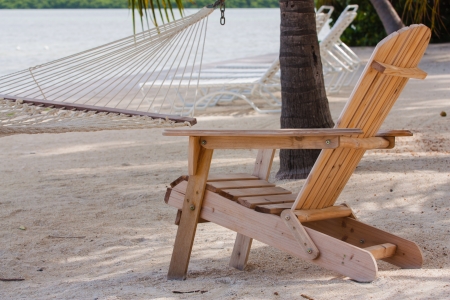 The photo shows a wooden chair on the beach.の写真素材