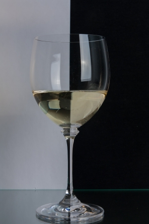 The photo shows the glass of wine on the background of two colors.の写真素材