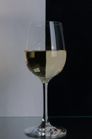 The photo shows the glass of wine on the background of two colors.の写真素材