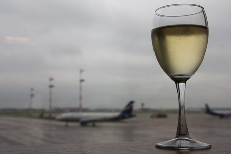 The photo shows the glass of white on the table in airport.の写真素材
