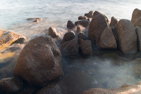 Pictured the stones on the coast with water in motion blur.の写真素材