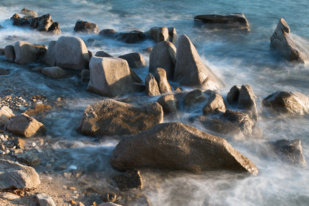 Pictured the stones on the coast with water in motion blur.の写真素材