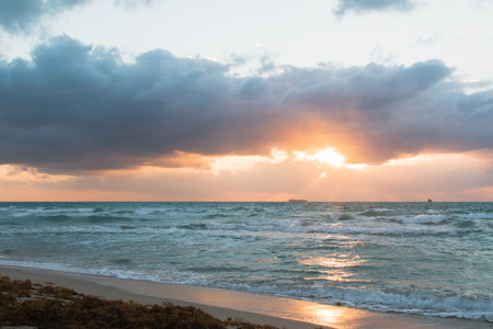 A ray of the rising sun breaks through the clouds in the ocean.の写真素材