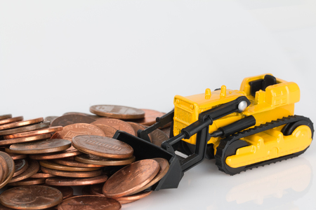 In the photo you see a toy bulldozer that rakes coins.の写真素材