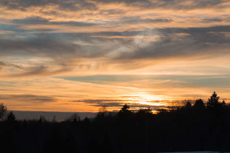 The photo shows a sunset in the park on a winter evening.の写真素材
