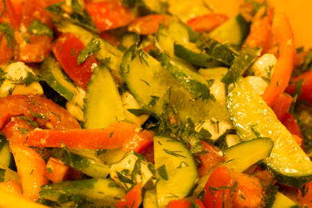 In the photo you see a salad of fresh tomatoes and cucumbers with feta cheese and herbs.の写真素材