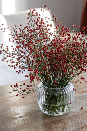 Bouquet of multiflora (branches with fruits) in a ribbed glass clear vase