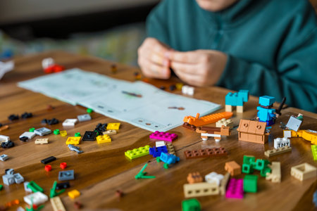Czech republic, Krecovice - December 31, 2023: child in a sweatshirt assembles LEGO Minecraft...