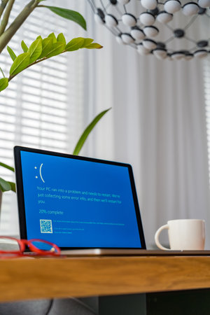 Prague, Czech Republic - September 13, 2024: Blue screen of death on a laptop at home officeのeditorial素材