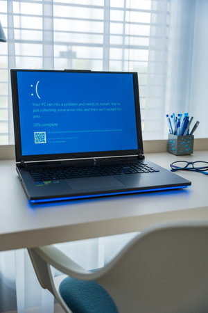 Prague, Czech Republic - September 11, 2024: Blue screen of death on a laptop at home officeのeditorial素材