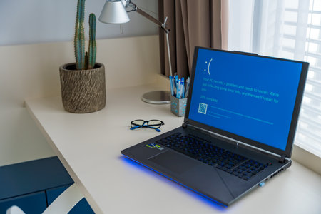 Prague, Czech Republic - September 11, 2024: Blue screen of death on a laptop at home officeのeditorial素材