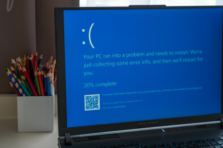 Prague, Czech Republic - September 11, 2024: Blue screen of death on a laptop at home officeのeditorial素材