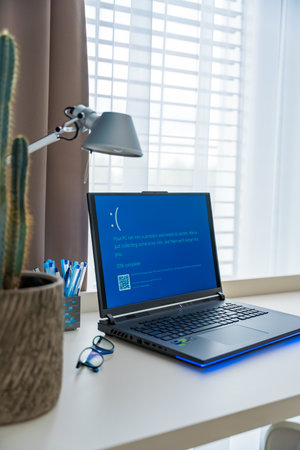Prague, Czech Republic - September 11, 2024: Blue screen of death on a laptop at home officeのeditorial素材