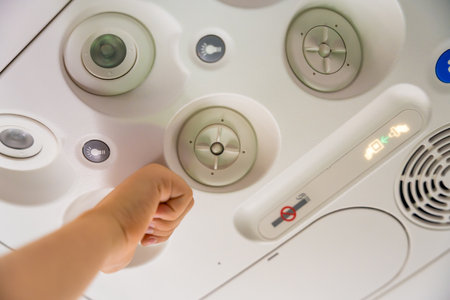 Hand adjusting the overhead panel on an airplane