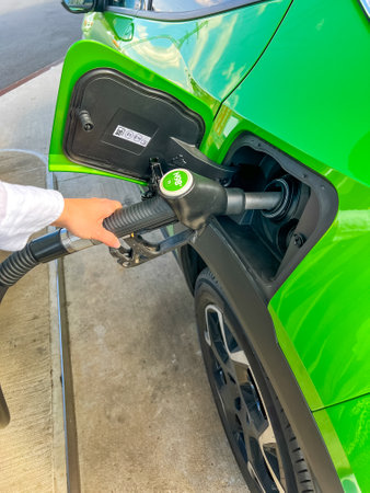 Close up view of refueling a green car in summer travel.