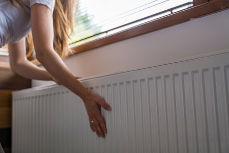 Adjusting the radiator at home during the heating seasonの写真素材