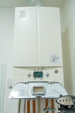 Osnice, Czech Republic - September 20, 2024: Wall-mounted boiler with open control panel in a homeのeditorial素材