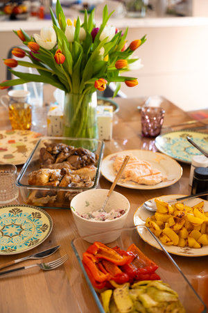 A beautifully set dining table with a vibrant tulip bouquet as a centerpieceの写真素材