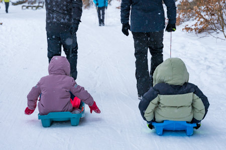 Family sledding through snowy forest path in Spindleruv Mlyn, Czech Republic