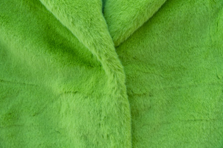 Close-up of green faux fur coat made of recycled polyester.