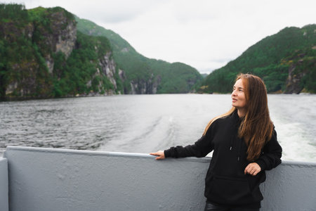 Confident woman with youthful look on fjord cruise near Bergen, Norwayの写真素材