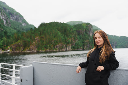 Woman with air touch hair on ferry in Norwegian fjord near Bergenの写真素材