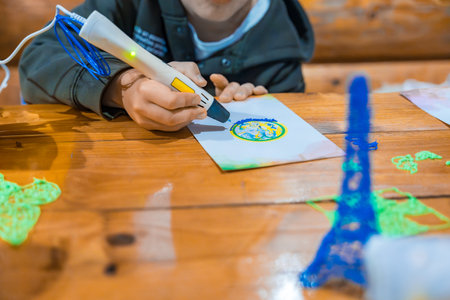 Child using 3D pen to create colorful drawings and objects. Selective focusの写真素材