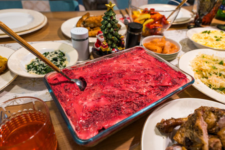 Traditional festive table with herring under a fur coat salad and homemade holiday dishesの写真素材